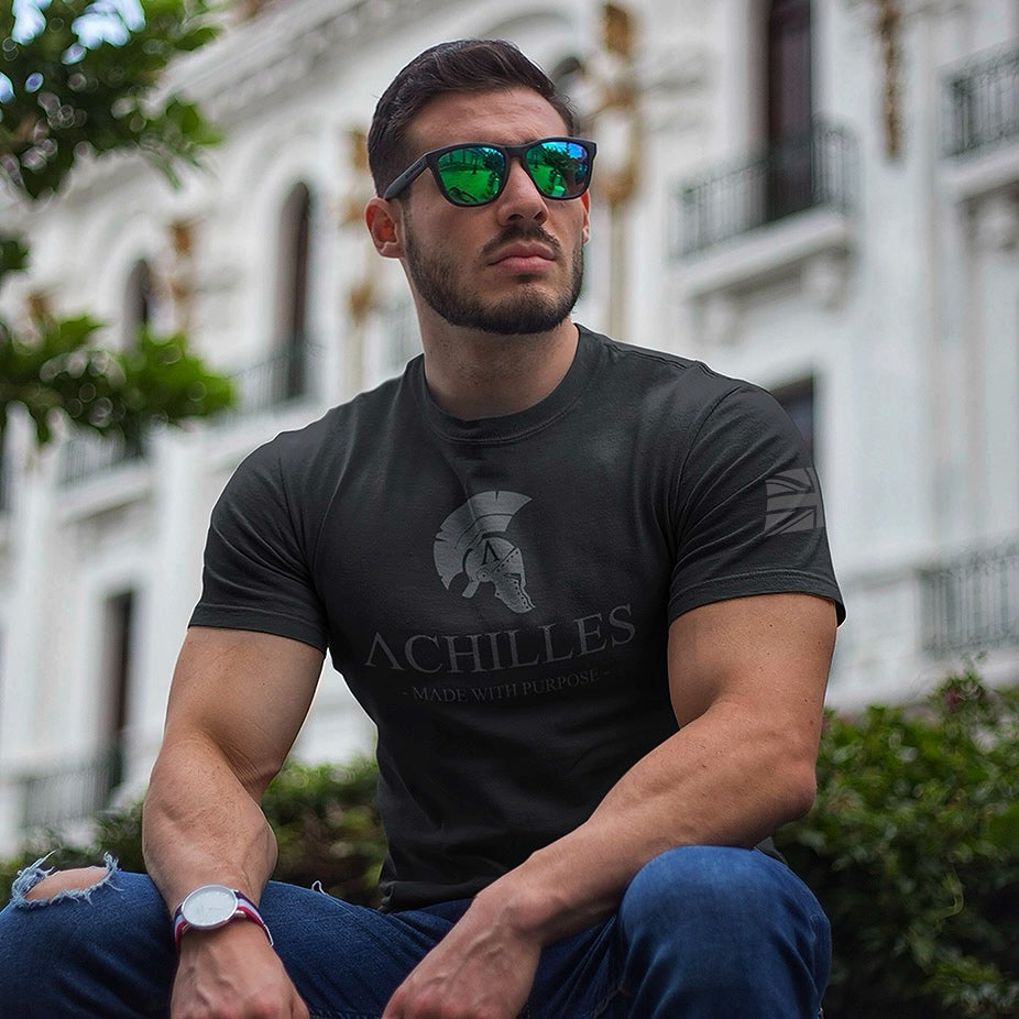 man wearing black short sleeve Achilles Tactical Clothing Brand T-shirt with grey signature design across chest