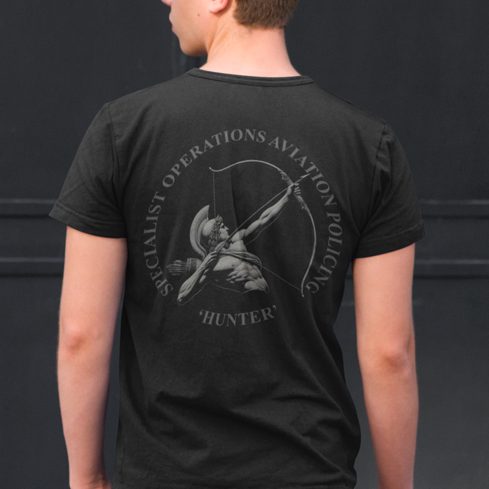 Back view of man wearing Black short sleeve unisex fit original cotton T-Shirt by Achilles Tactical Clothing Brand printed with Large Hunter police design across back