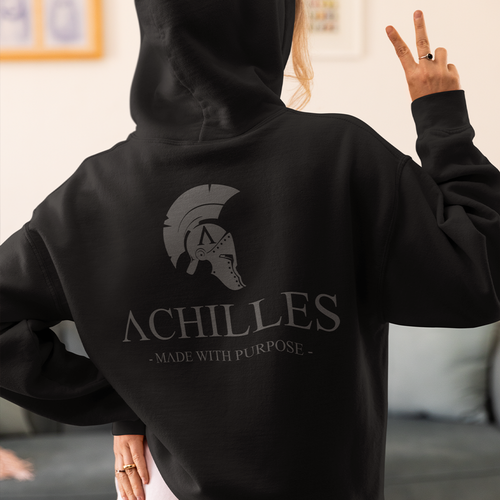 Close up of Back of woman wearing Black unisex fit Pullover Hoodie by Achilles Tactical Clothing Brand printed with Large Signature design across back