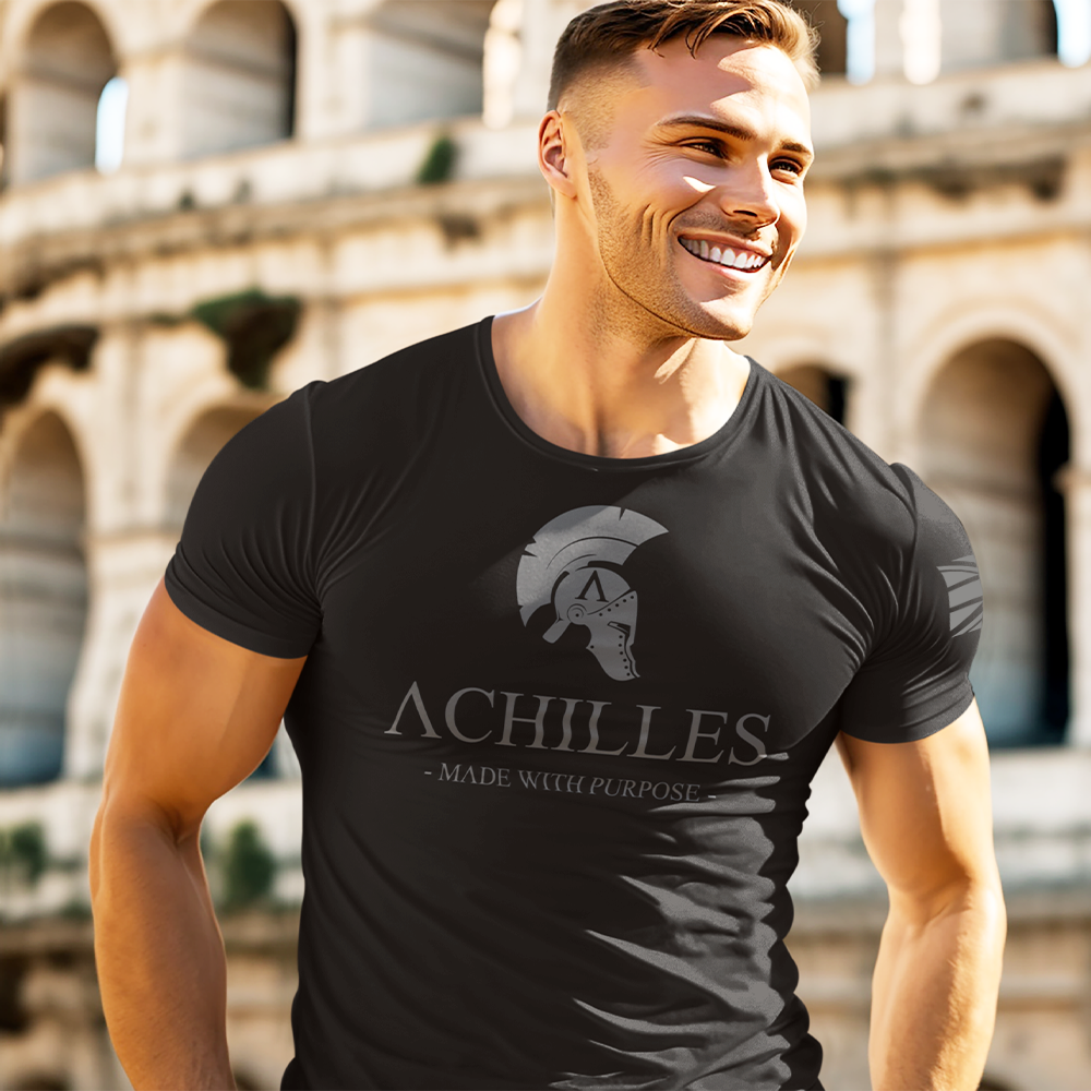 Front view of a fit and athletic looking man wearing a black short sleeve athletic fit t-shirt with Achilles logo in grey printed across the chest